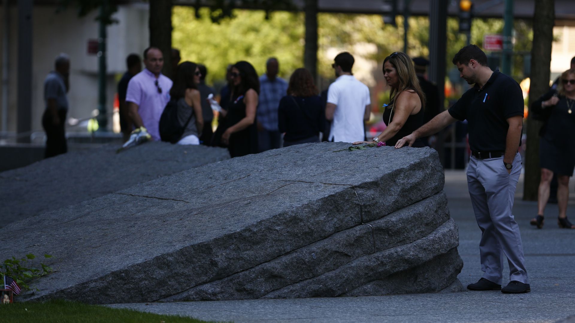 People touching the monoliths on the Memorial Glade
