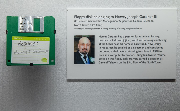A green floppy disk marked "RESUME: Harvey J. Gardner III" is mounted alongside an exhibition wall label that provides background about the artifact.