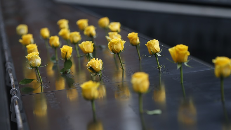 An array of yellow roses inserted into the bronze Memorial parapets.