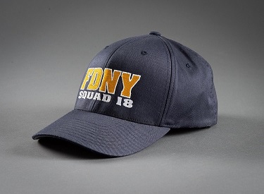 Blue baseball cap with FDNY in gold yellow letters and Squad 18 under that in white letters