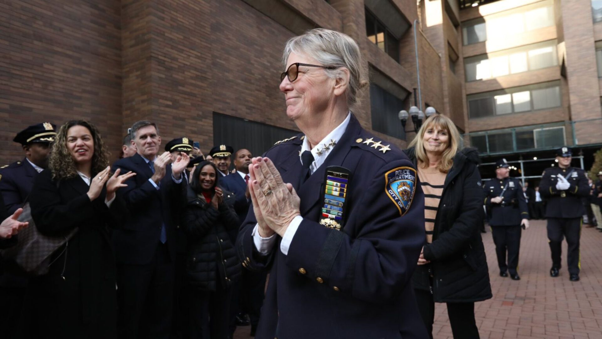 Chief Tobin claps, surrounded by officers 