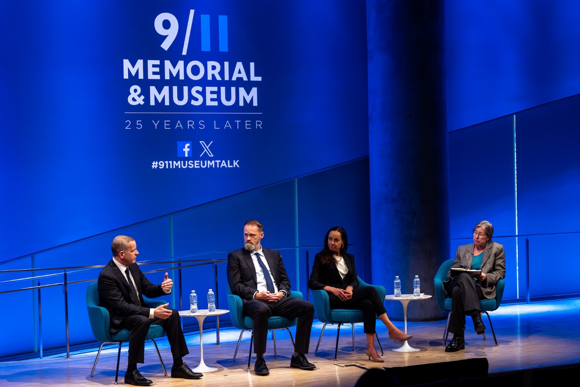 four people on stage under a 911 logo