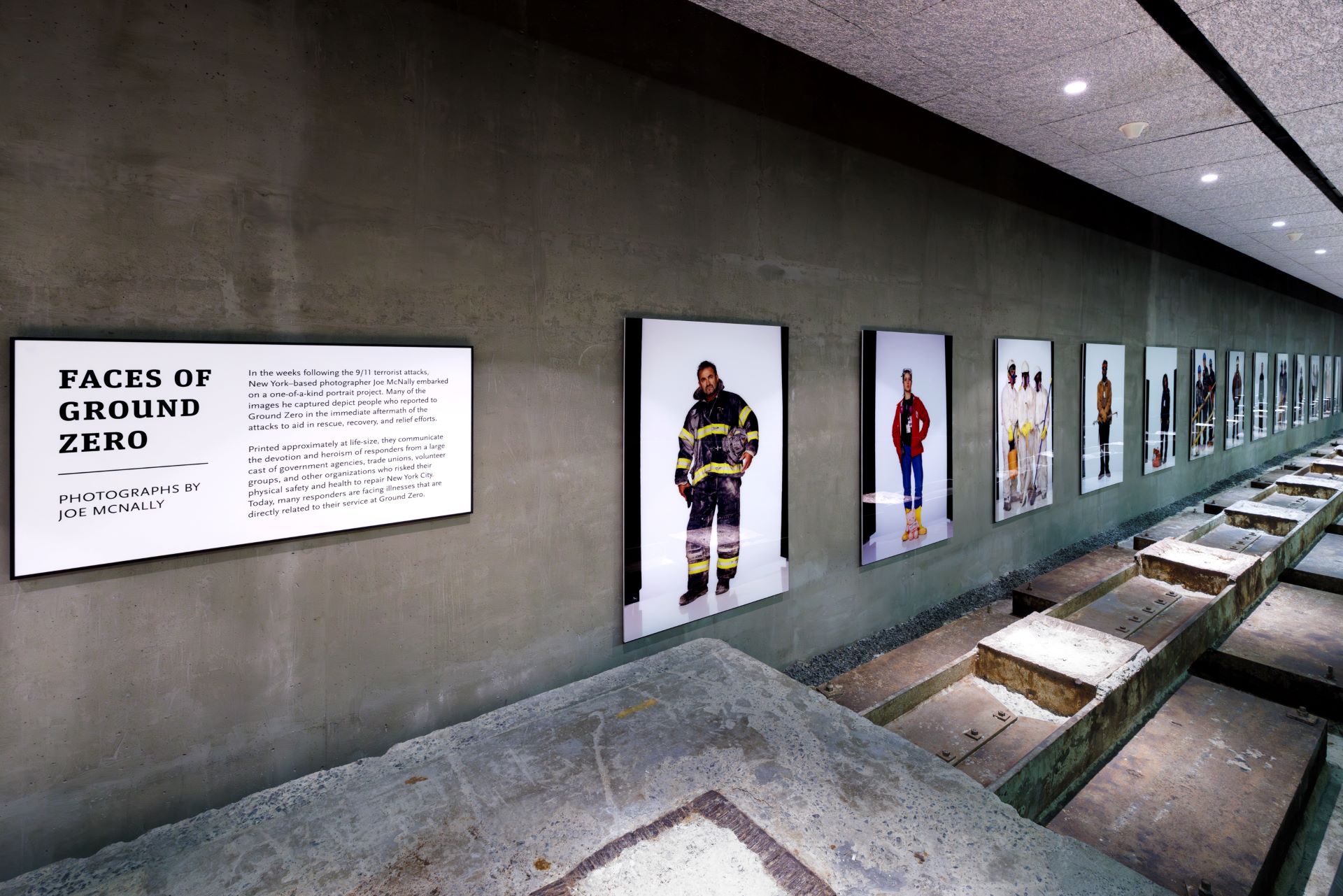 Hallway of the McNally installation, with text and photos visible along a cement wall