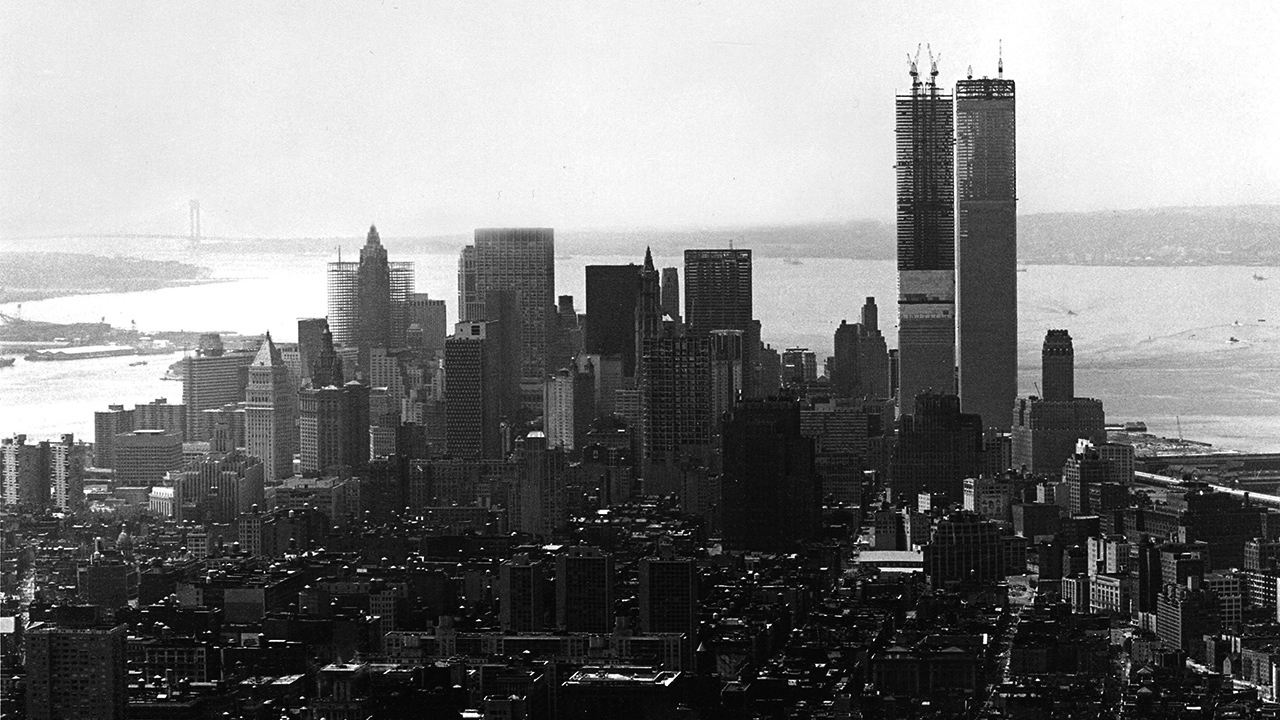 Black and white aerial south view of lower Manhattan with the Twin Towers being built.