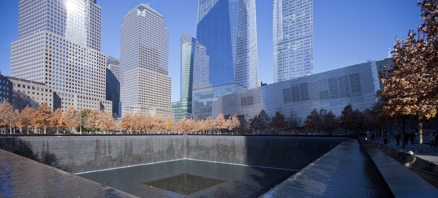 Fall foliage lines the Memorial pools, with the lower Manhattan skyline in the background