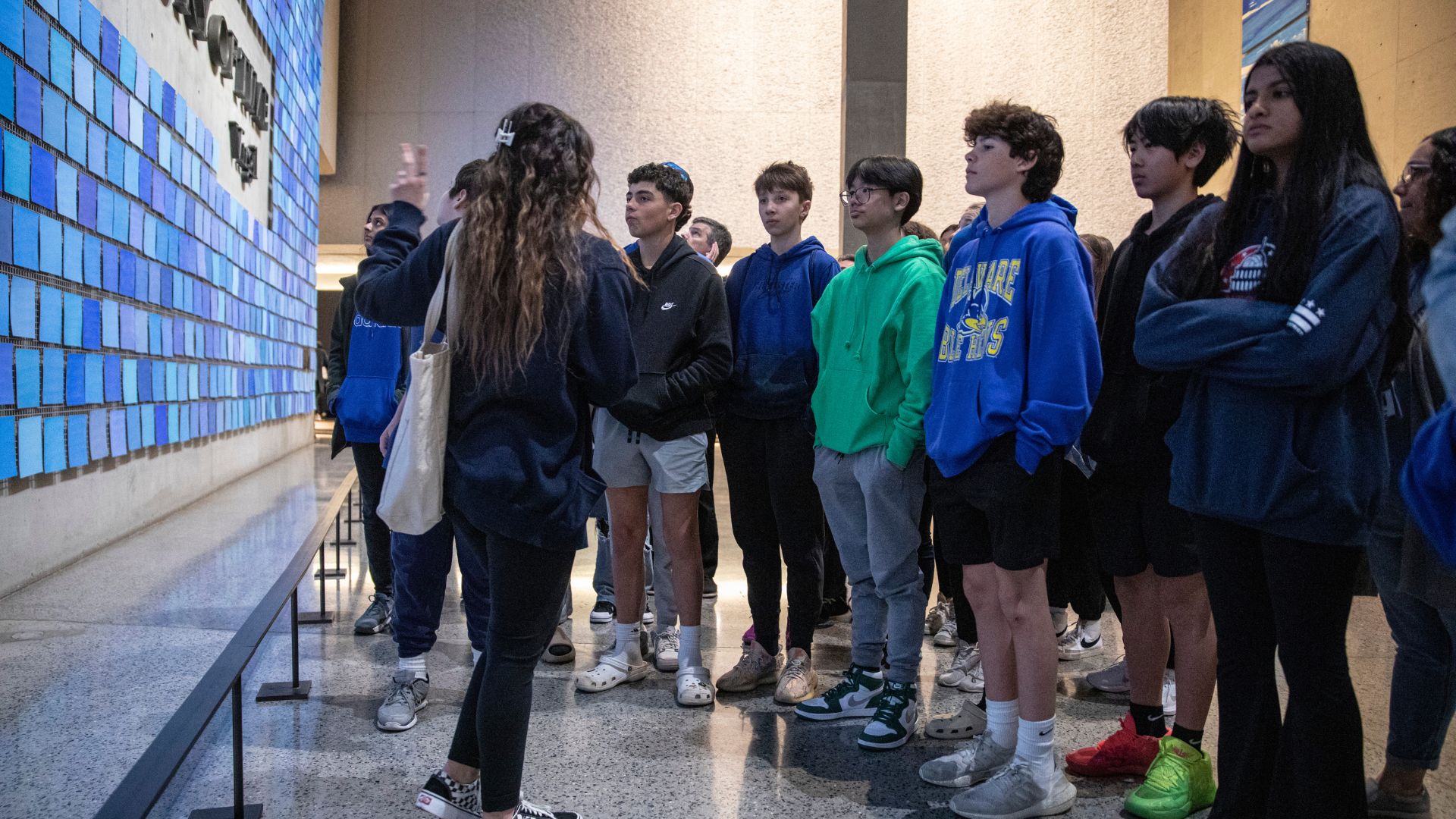 A group of students and a tour guide looking at the Spencer Finch installation "Trying to Remember the Color of the Sky on That September Morning"Color of the Sky 