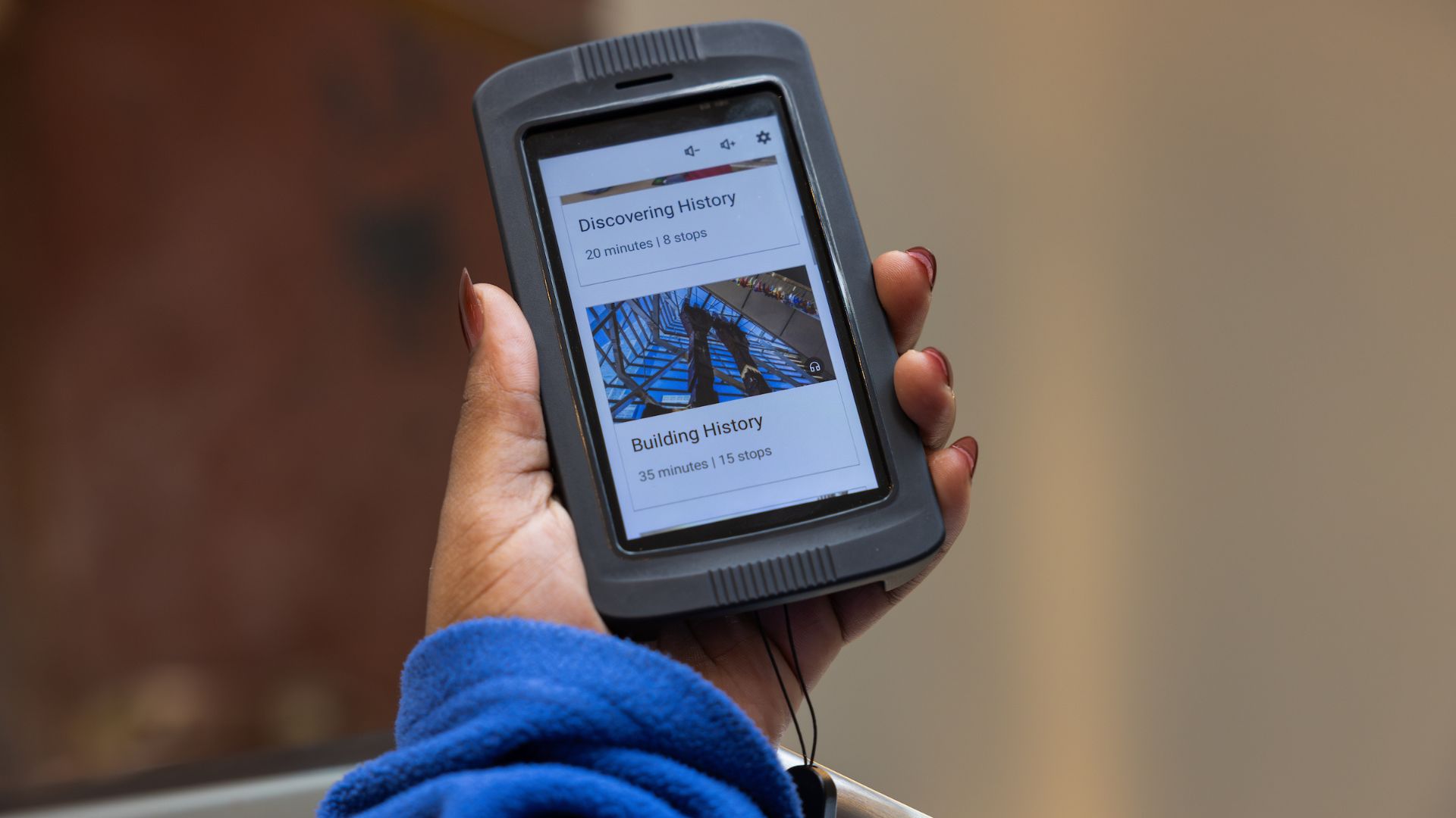 The screen of an audio device in a Museum visitor's hand displaying tour options 