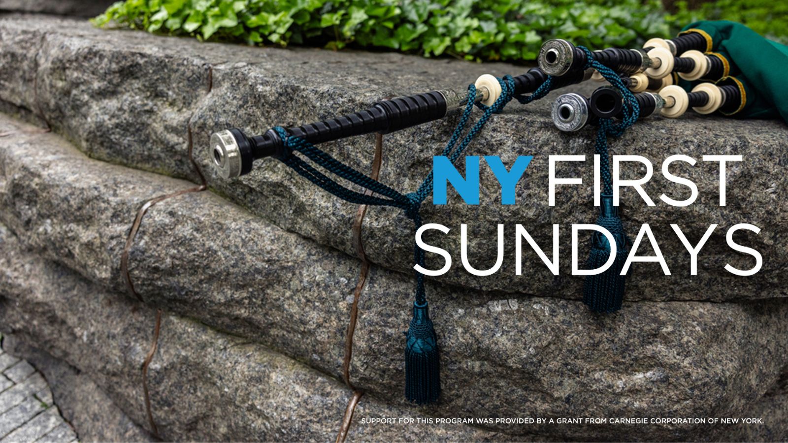 Close-up of a stone monolith, embedded with steel, with a bagpipe on top