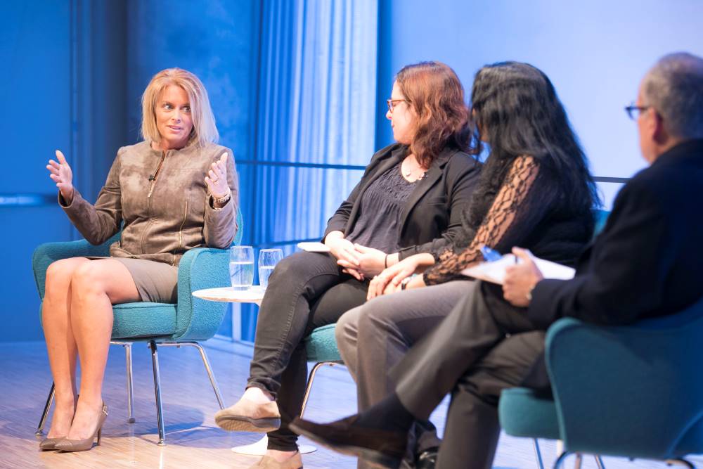 NY1 anchor Kristen Shaughnessy, New York Times correspondent and CNN analyst Maggie Haberman, and Associated Press reporter Deepti Hajela are seen seated onstage at the Museum Auditorium. Shaughnessy gestures with both hands as she speaks. The other two attendants and Clifford Chanin, the executive vice president and deputy director for museum programs, listen on to her right.
