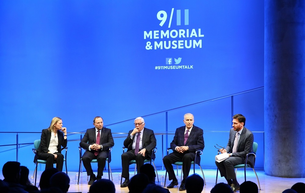 In this wide-angle photo, a woman and four men sit onstage while taking part in a public program about sports after 9/11 at the Museum Auditorium. To the left is WNBA Founding President and Big East Conference Commissioner Val Ackerman. To the right of her is NHL Commissioner Gary Bettman. To the right of him is NBA Commissioner Emeritus David J. Stern. To the right of him is former NFL Commissioner Paul Tagliabue. At the far right is Mike Greenberg, longtime SportsCenter anchor and current h