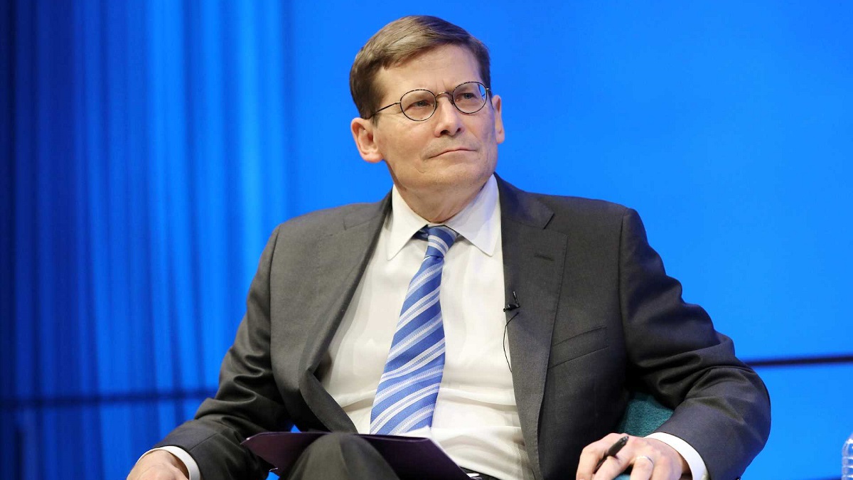 Former Acting CIA Director Michael Morell looks to his left as he sits onstage in a suit and tie at the Museum Auditorium. His hands are resting on his chair and a clipboard is balanced in his lap.