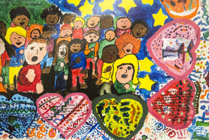 Detail shot of the children's mural, featuring multicolored hearts and people singing