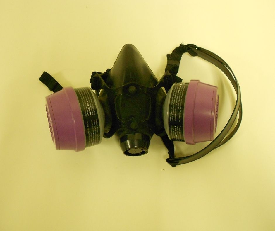 A black and red respirator against a yellow background