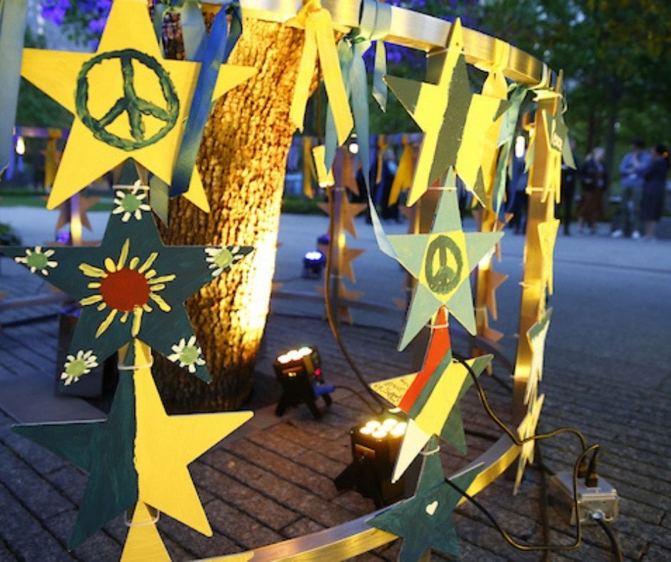 Hand-painted wooden stars hung from the railing of the Survivor Tree