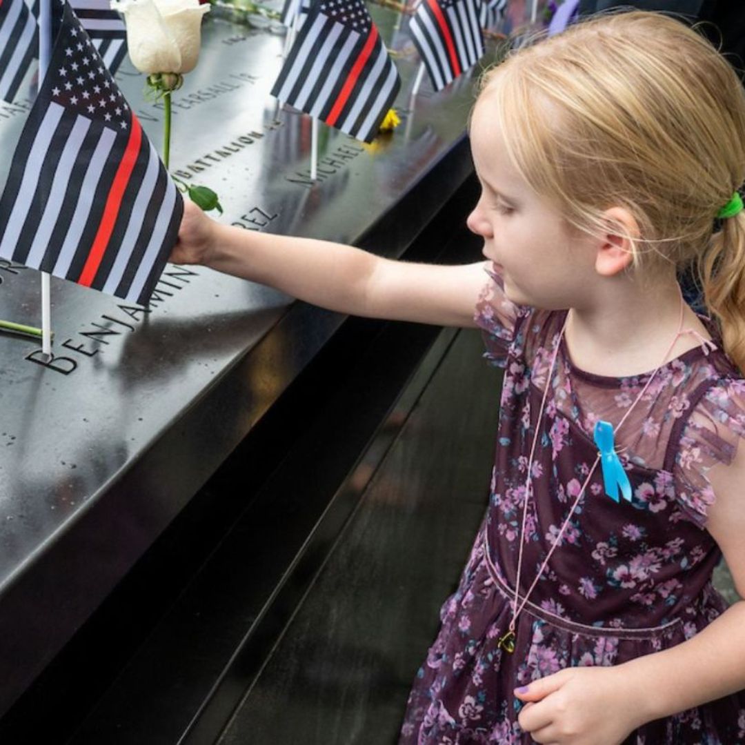 A child places a flag on the Memorial
