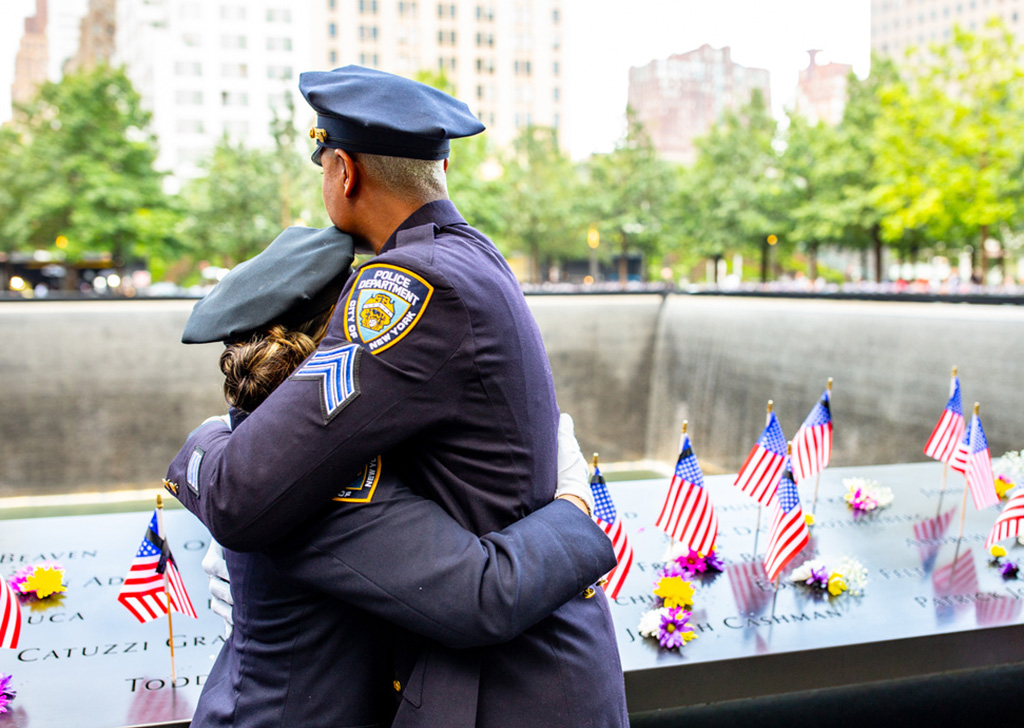 NYPD officers embrace at the Memorial