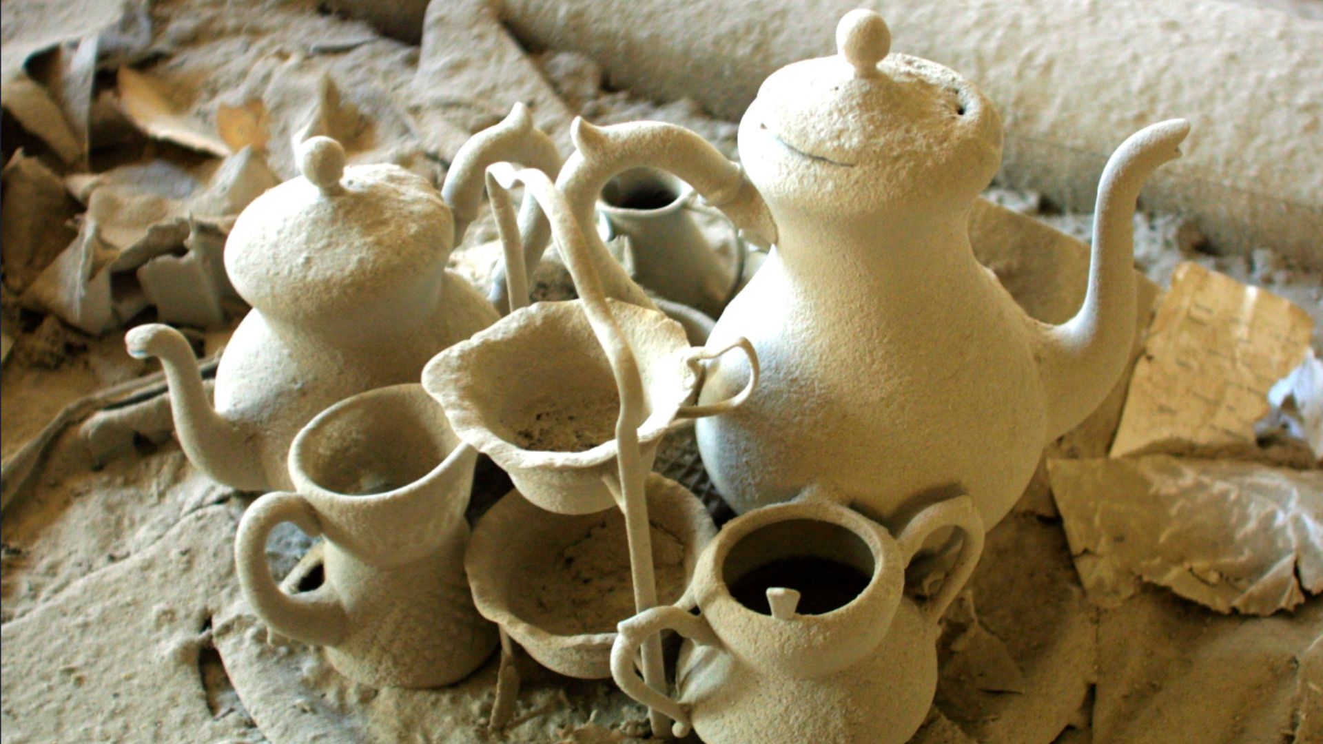 A tea set covered in heavy dust. 