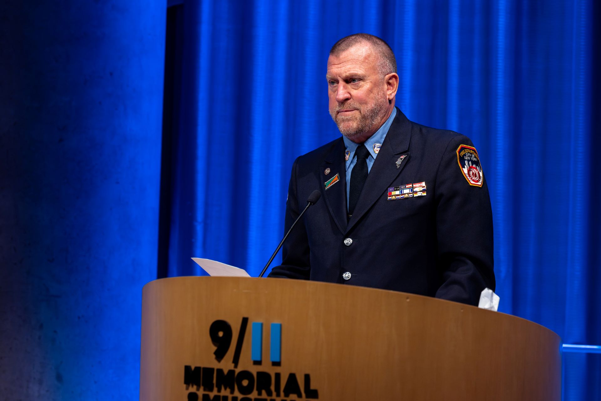 A man in FDNY uniform introduces Joe McNally