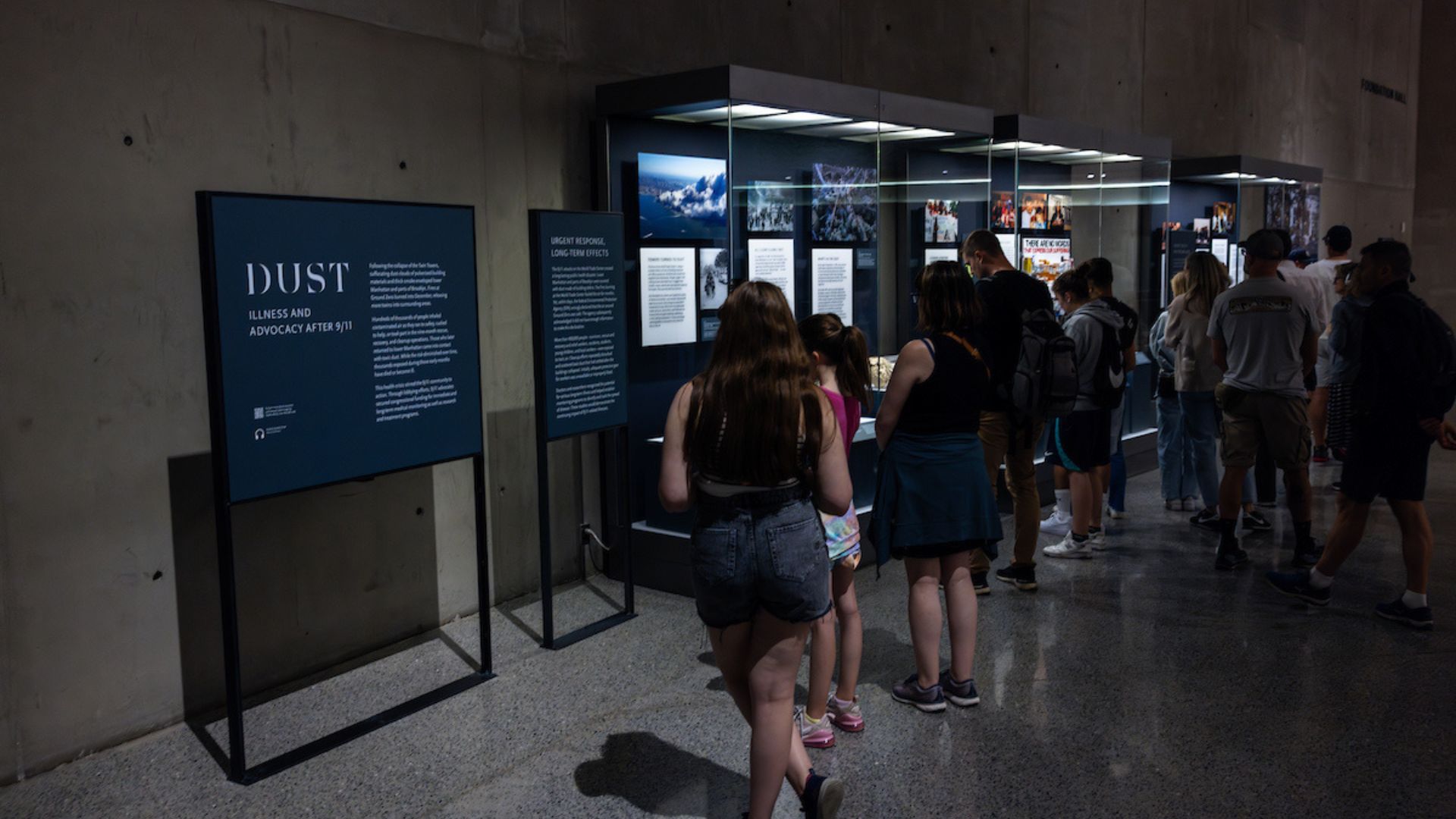 A small crowd views the display cases for the installation "Dust" in Foundation Hall