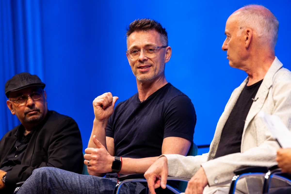 a panelist gestures and speaks in between two others