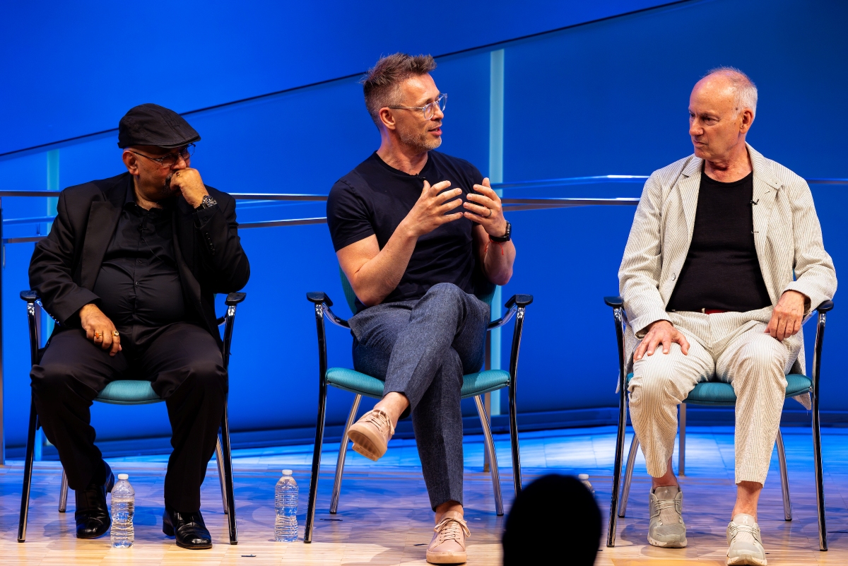 Three panelists talk on stage