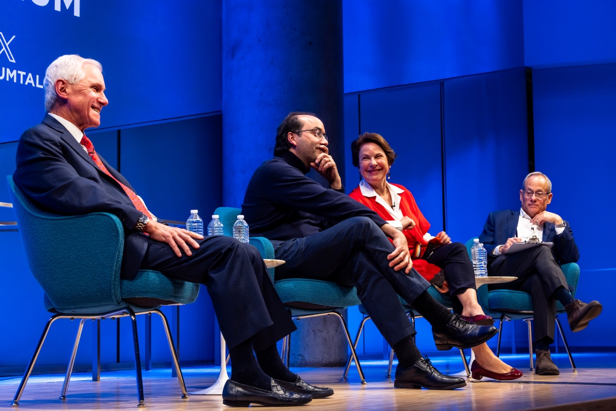 Four people sit on stage, having a conversation 