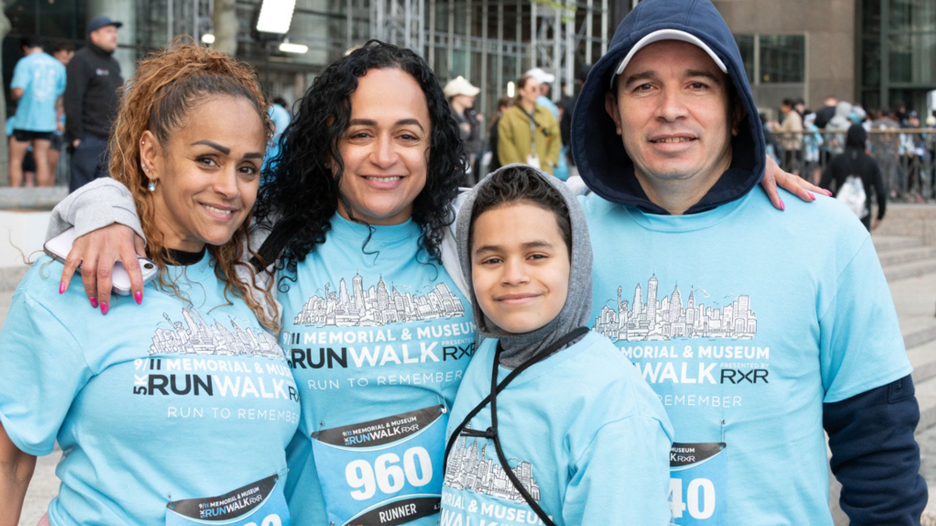Four people wearing official 5K tee shirts pose and smile for a photo