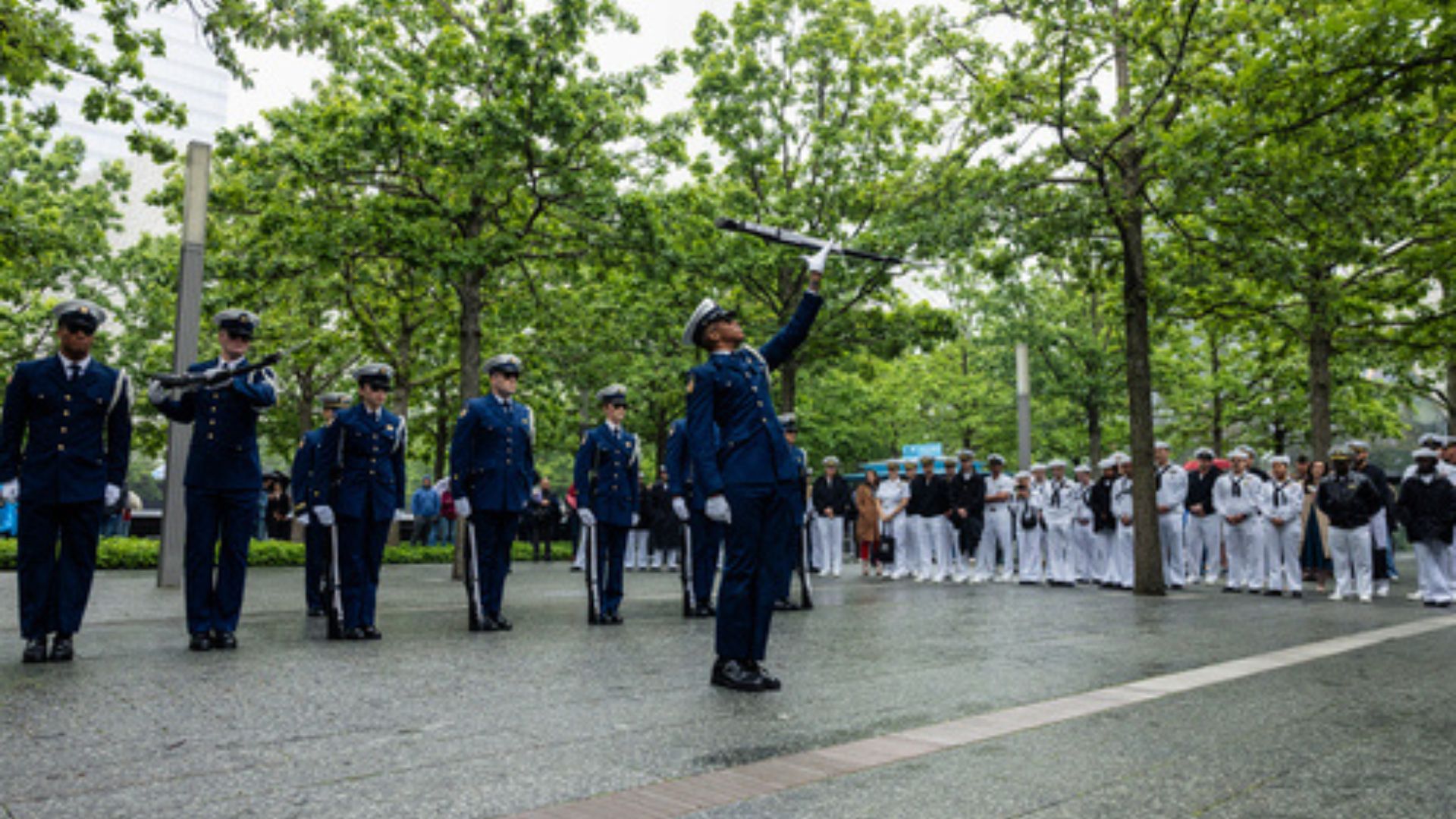 Uniformed men and women line up on the plaza
