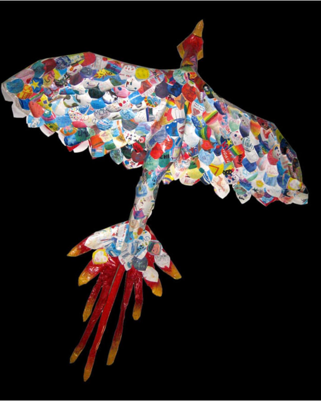 Hanging sculpture of a phoenix made of paper feathers, set against a black background