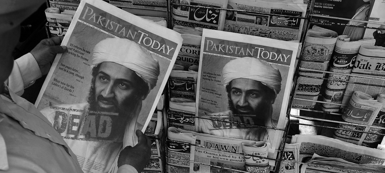 Man holding ‘Pakistan Today’ newspaper. The front cover shows image of Osama bin Laden with word “DEAD” stamped on it. 