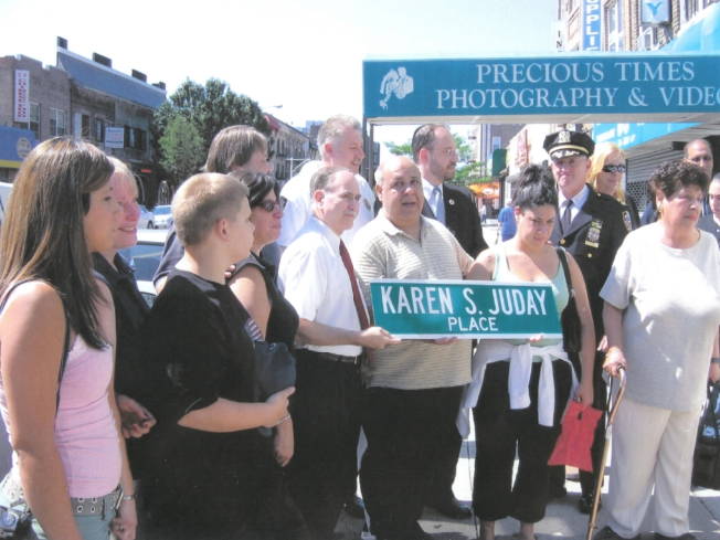 Photograph of a crowd of people standing on a street corner at a dedication ceremony. 