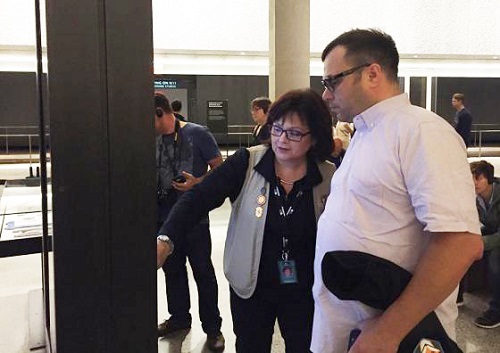 Sonia Agron, wearing a docent's vest, helps a visitor to the 9/11 Memorial Museum navigate the space. 