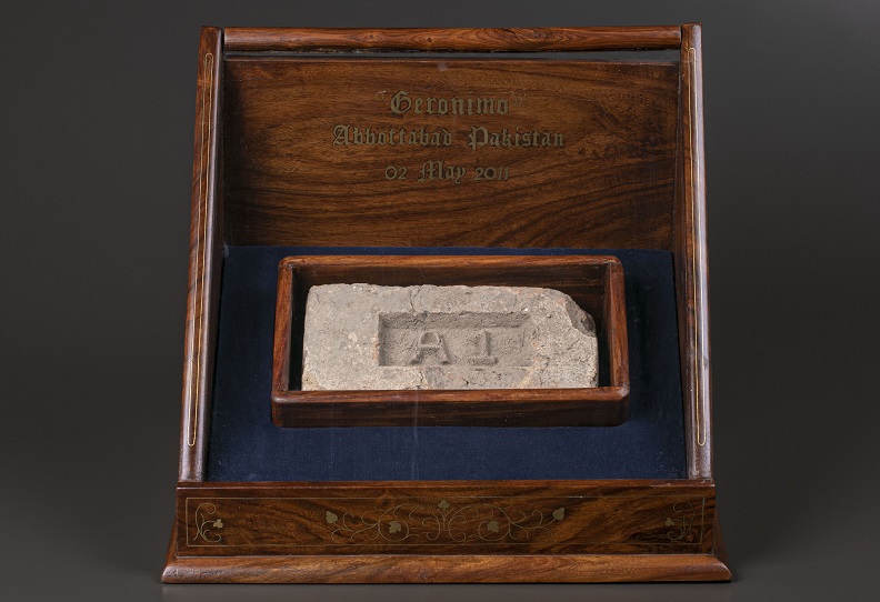 Beige masonry brick with A1 imprint in a wooden display case.