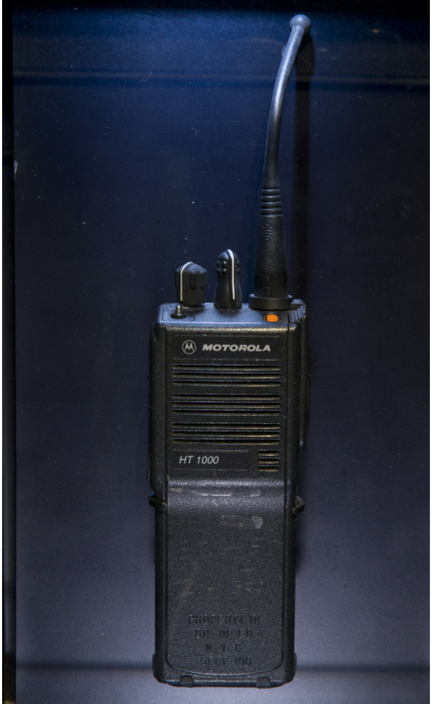 A black hand-held radio against a dark blue background