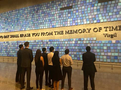 Back view of men and women looking at blue Spencer Finch remembrance wall
