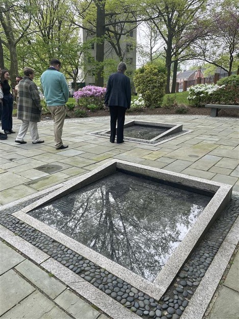 Elizabeth Hillman looks at a memorial plaque inset into a stone garden patio.