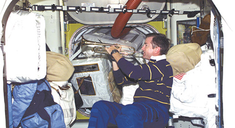 image of astronaut in a spaceship playing the trumpet