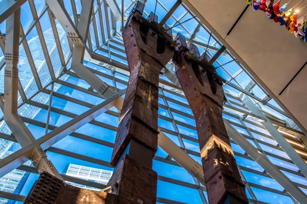 Steel beams raise into sky with glass windows behind