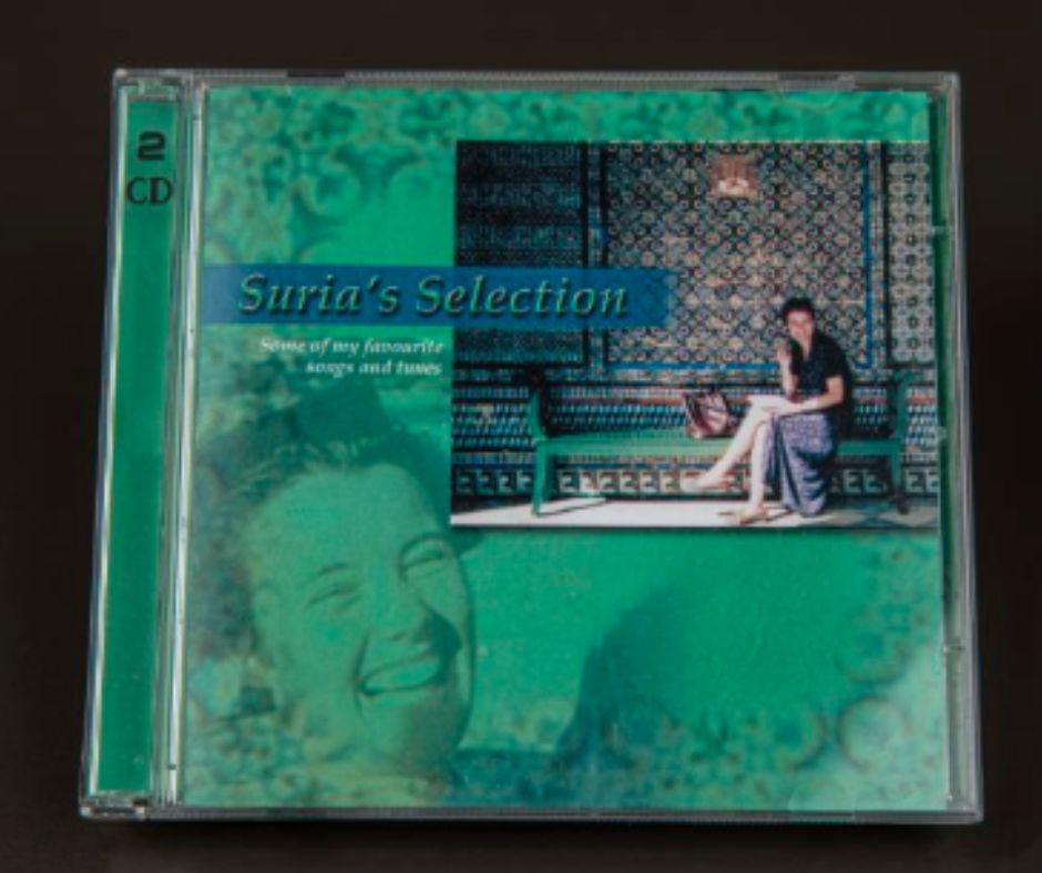 A compact disc with a green cover and a photograph in the top right corner.