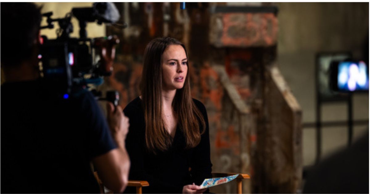 A speaker is interviewed on camera while seated in a studio setting.