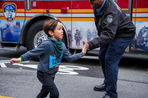 Kid running high fives a first responder