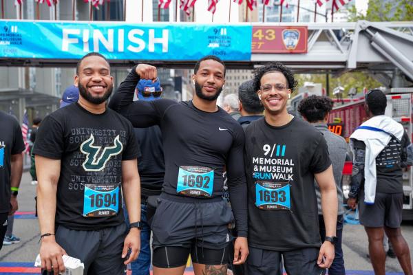 Three men celebrating the race at the finish line