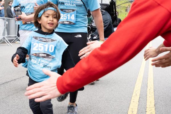 a child gives a high five to an adult in a red shirt