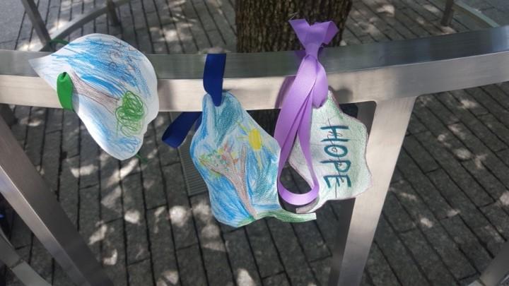 Light blue and purple paper leaves along the railing of the Survivor Tree