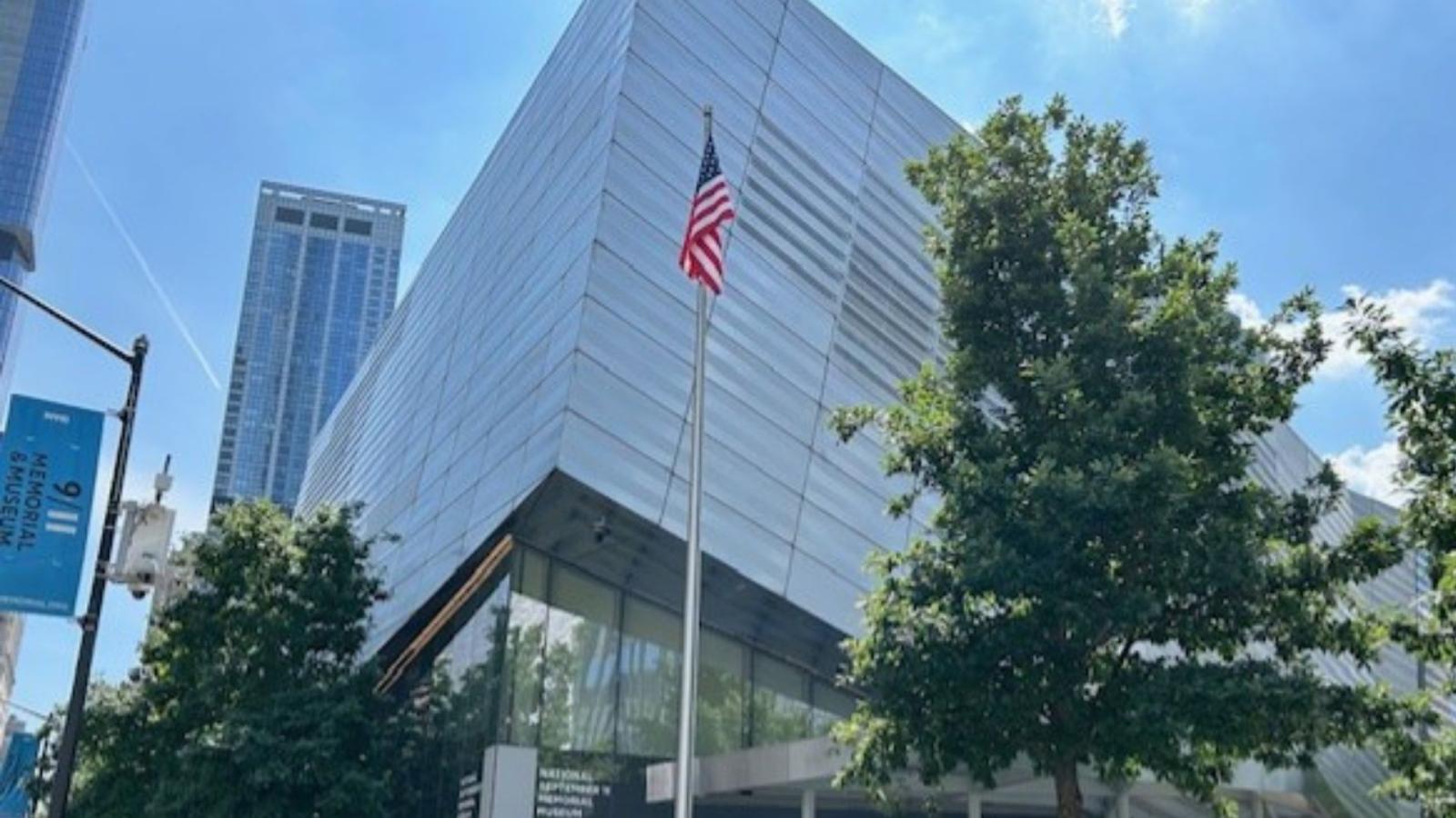 Exterior of the 9/11 Memorial Museum, with an American flag visible in the foreground