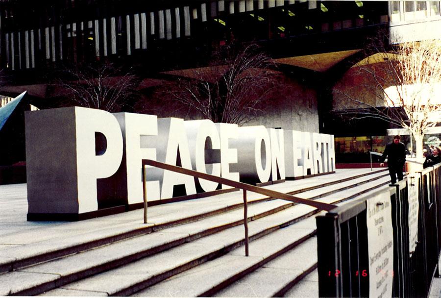A large “Peace on Earth” sign is displayed on the steps of the World Trade Center in 1999.
