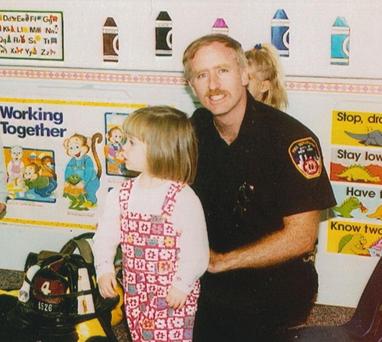 A young Caitlin Leavey stands beside her father, FDNY Lieutenant Joseph Leavey, in this photo from 1994.