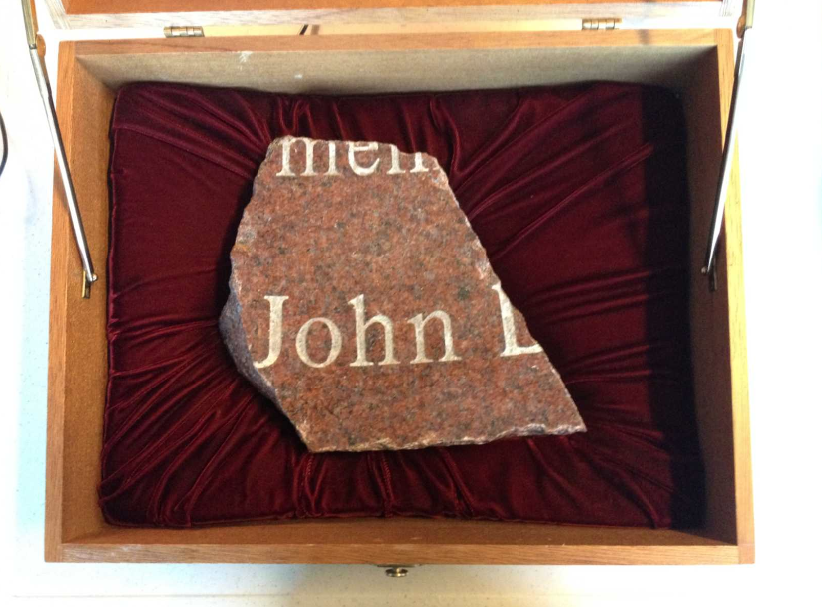 A surviving fragment of a fountain memorializing the victims of the 1993 World Trade Center bombing is displayed in a box. The name “John” is visible on the fragment.